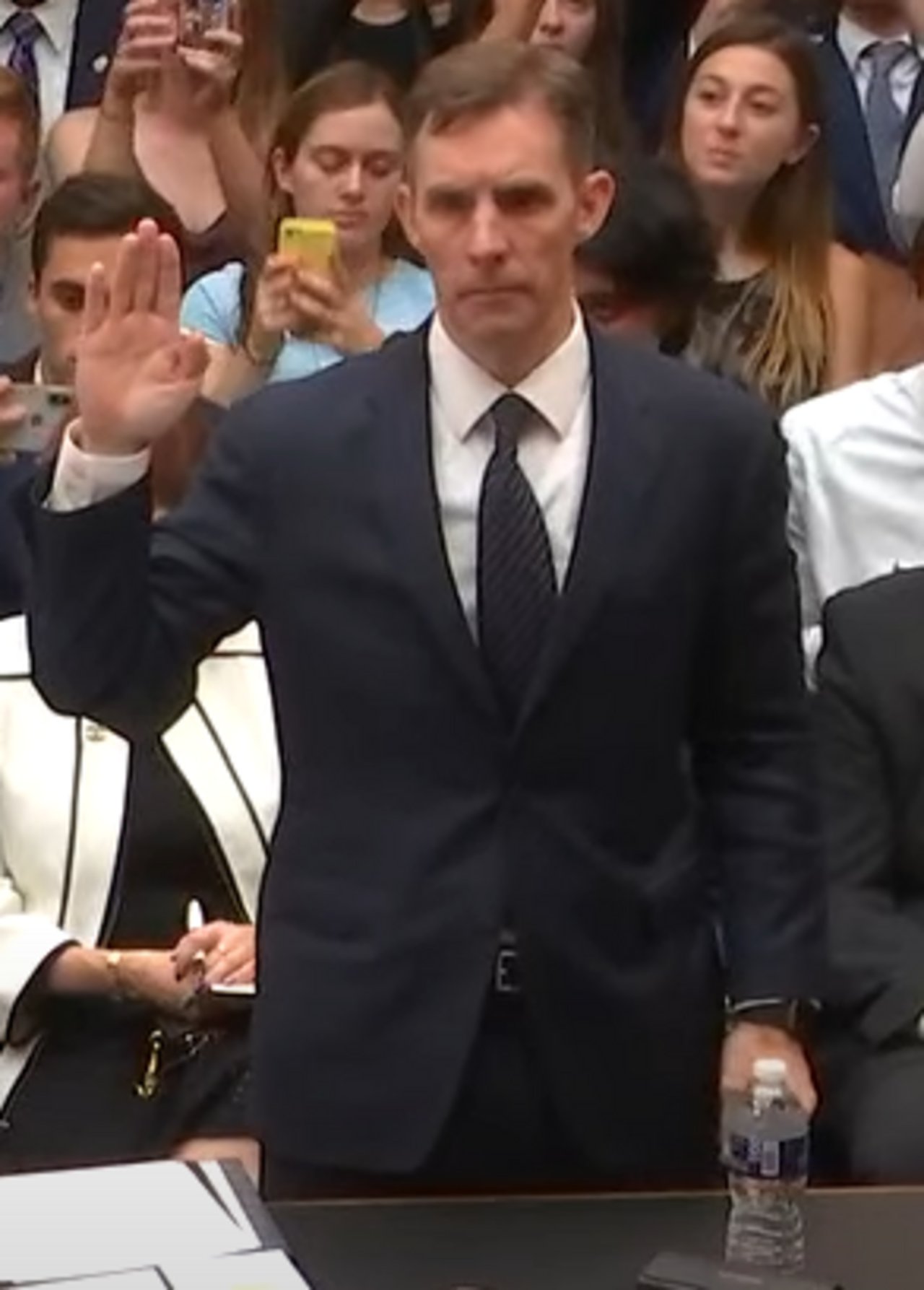 The image represents former Deputy Special Counsel Aaron Zebley as he was being sworn in by Chairman Adam Schiff during former Special Counsel Mueller's House Intelligence Committee. To his right (not